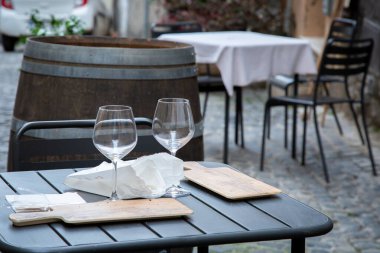 İki zarif şarap kadehi ve üzerine belirgin bir tahta kesme tahtası olan güzel bir masa.