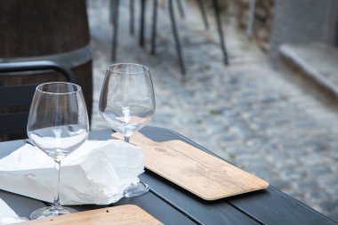 Küçük bir yemek masası zarif bir şekilde iki şarap bardağı ve masaların üzerinde düzgünce katlanmış bir peçeteyle kurulur.