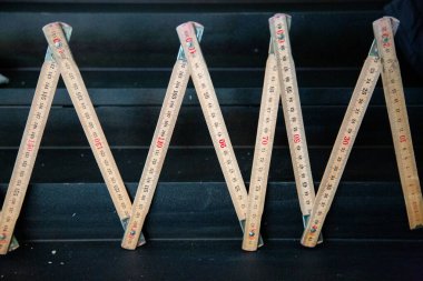 Üzerine doğru ölçümler ve kullanışlı kullanım için tasarlanmış m oymalı veya yazdırılmış harfi içeren ahşap bir cetvel.