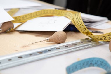 Ölçüm bandı bir cetvelin hemen yanındaki masanın üzerinde duruyor, hem doğru ölçümler için temel araçlar hem de el işi görevler için.