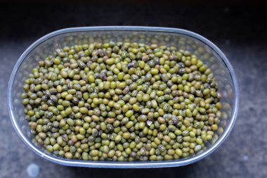 Taze yeşil fasulyelerle dolu bir kase şu anda bir masada dinleniyor, canlı rengini ve iştah açıcı görünümünü sergiliyor.