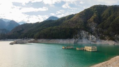 Tramonti di sotto, İtalya - Redona yapay gölü manzarası eski binaların yükselen kalıntılarıyla