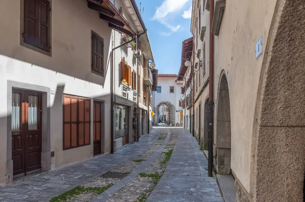 stock image Tolmezzo, Italy (15th July 2023) - The central and old via Giovanni da Tolmezzo street with the ancient gate of Porta di sotto at the end of it