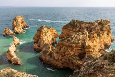 Portekiz 'in Algarve bölgesindeki engebeli Atlantik okyanus kıyılarının dramatik manzarası