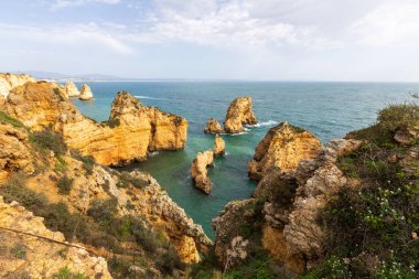 Portekiz 'in Algarve bölgesindeki engebeli Atlantik okyanus kıyılarının dramatik manzarası