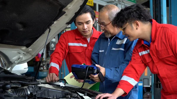 차고에 소프트웨어 수선에 의하여 엔진을 검사하는 아시아 기계장치 매니저 견습생 — 스톡 사진