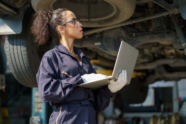 African American Mechanic Woman Using Laptop Computer Checking List Undercarriage — Stock Photo, Image