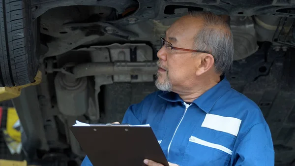 Asiatische Mechaniker Senior Mann Mit Clip Board Checkliste Bremse Reifen Stockbild