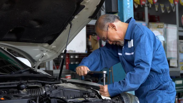 Asiatische Mechaniker Senior Mann Mit Steckschlüssel Reparatur Eines Autos Der Stockbild