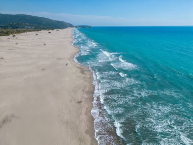 Mavi denizi ve turkuaz suyu olan güzel bir sahil.