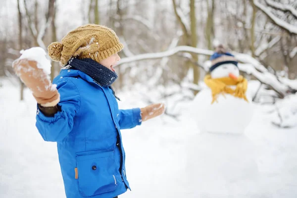 Mały Chłopiec Grający Śnieżki Zaśnieżonym Parku Dziecko Buduje Bałwana Aktywny — Zdjęcie stockowe