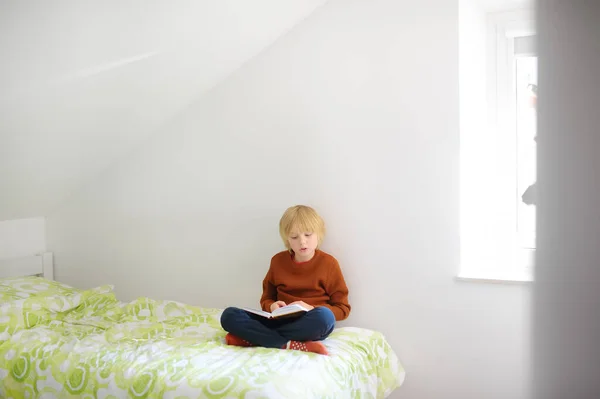 Akıllı Çocuk Yatakta Oturuyor Hevesle Ilginç Kitaplar Okuyor Çocuk Okuyucu — Stok fotoğraf