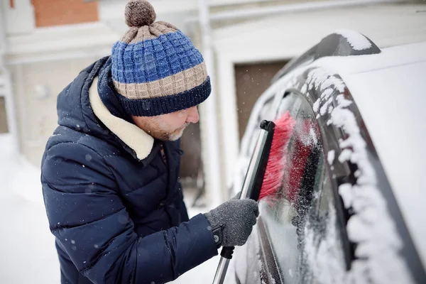 Starší Muž Čistí Auto Štětcem Sněžení Snowdrift Sněhové Bouři Kapotě — Stock fotografie