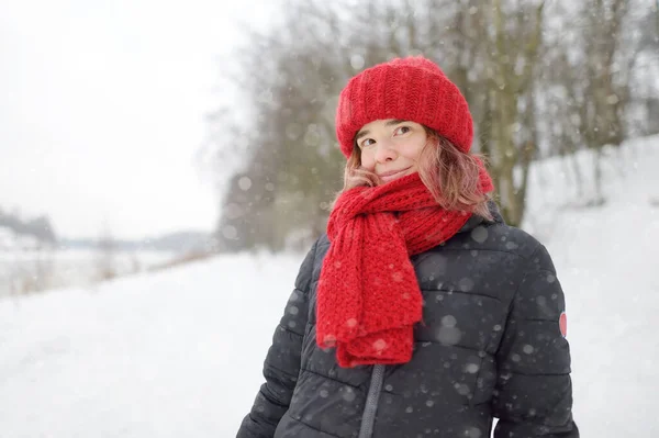 在冬季的降雪中 年轻美丽的 头戴红帽子 头戴围巾 头戴粉色头发的高加索女人的特写 自然美概念 — 图库照片