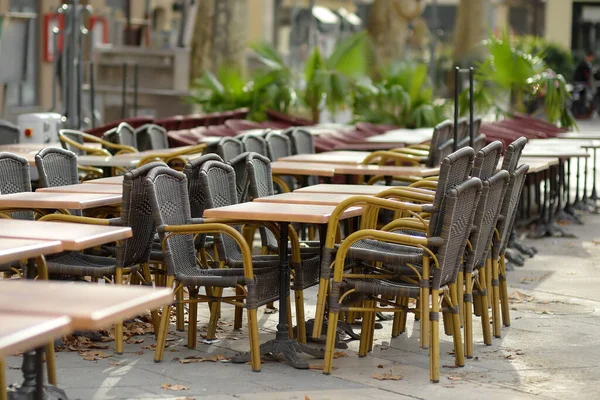 秋天的一天 一座欧洲城市的一个空的户外咖啡馆 椅子和桌子堆放在一起 落叶躺在地上 餐厅关门了本季结束 休假日 — 图库照片