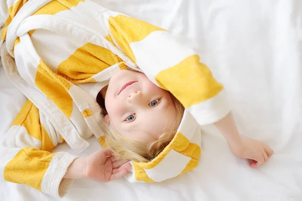 穿着浴衣的小孩的画像是醒来后躺在床上 孩子们回家穿的衣服男孩有早上的例行公事 并准备上幼儿园 懒虫宝宝可不想下床 — 图库照片
