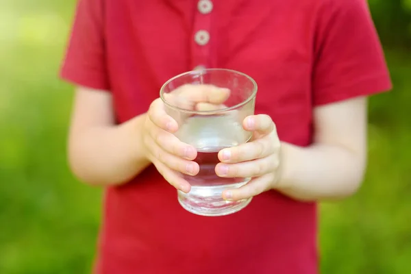 裏庭や自宅の庭で暑い晴れた夏の日に水を飲む小さな男の子 喉が渇いた 子供のための健康的な生活 — ストック写真