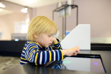 Küçük beyaz çocuk bir bilim müzesinde sergi arıyor. Keen çocuk sergileri keşfediyor. Çocuklar için eğitim ve eğlence. Anaokulu çocukları olan aile aktiviteleri.