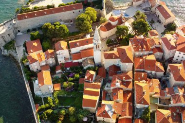 Karadağ 'ın antik Budva kentinin panoramik gün batımı drone görüntüsü. Kırmızı çatıları olan eski bir ortaçağ kasabası. Adriyatik Denizi kıyısındaki Picturesque Kotor Körfezi. Budva, Karadağ 'ın en popüler tatil beldesi