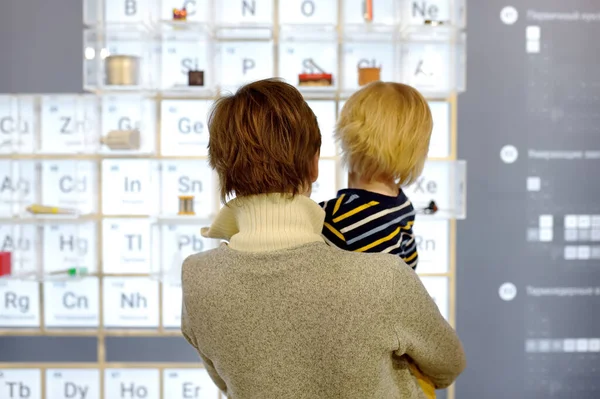 stock image Little boy and woman looking an exposition in a scientific museum. Child is interested in chemistry. Education and entertainment for children. Activities for family with preschooler kids.