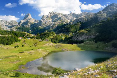 Breathtaking landscape of mountain valley with Bukumirsko Lake in alps of Montenegro. Stunning view of mountains and valleys in sunset light. Hiking and tracking concept