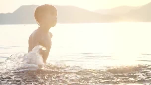 日落时 快乐的孩子在海里游泳 快乐的男孩在湖中游泳时 玩得很开心 并与水一起飞溅 学校放假期间儿童的积极休闲活动 — 图库视频影像
