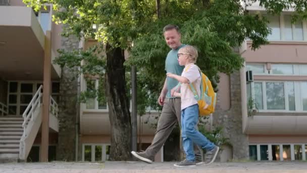 Ein Grundschüler Geht Begleitung Seines Vaters Mittleren Alters Von Der — Stockvideo