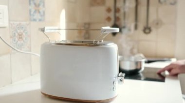 Orta yaşlı bir adamın kahvaltı hazırlarken çekilmiş yakın çekim videosu. Küçük bir tencerede yumurta ve kızarmış ekmek.