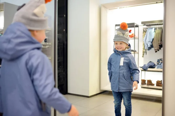 Roztomilý Chlapeček Zkouší Nový Kabát Klobouk Před Zrcadlem Obchodě Nebo — Stock fotografie