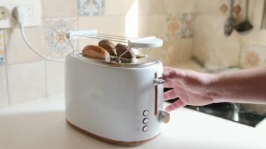Orta yaşlı bir adamın kahvaltı hazırlarken çekilmiş yakın çekim videosu. Küçük bir tencerede yumurta ve kızarmış ekmek..