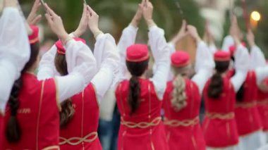 Geçit töreni katılımcıları. Şehrin sokaklarında geleneksel dans ve müzik kutlaması. Kırmızı elbiseli güzel kadınlar halk dansı yapar. Tanınmayan insanlar