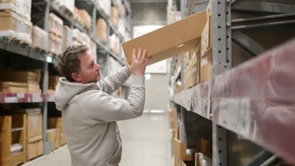 中年の男性は 店や倉庫で商品の箱を拾う 大型店でのセルフサービス 自分で行う家具の配達と組み立て — ストック動画