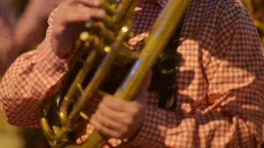 Geçit töreni katılımcıları. Şehrin sokaklarında geleneksel dans ve müzik kutlaması. Bir grup müzisyen şehir gösterisi sırasında rüzgâr pirinç enstrümanlarında müzik icra ediyor. Tanınmayan insanlar