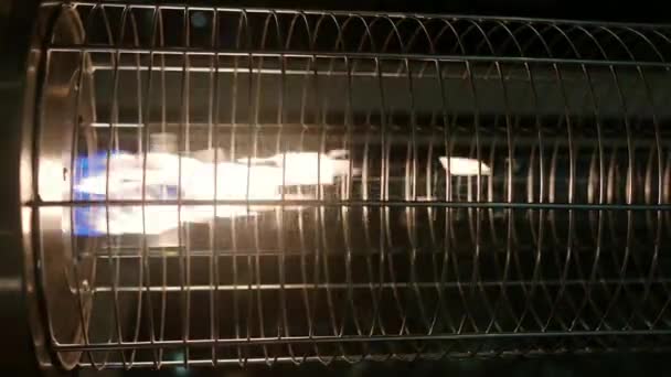 夜のカフェやレストランの外のパティオでストリートガスヒーターの垂直ビデオ 野焼き — ストック動画