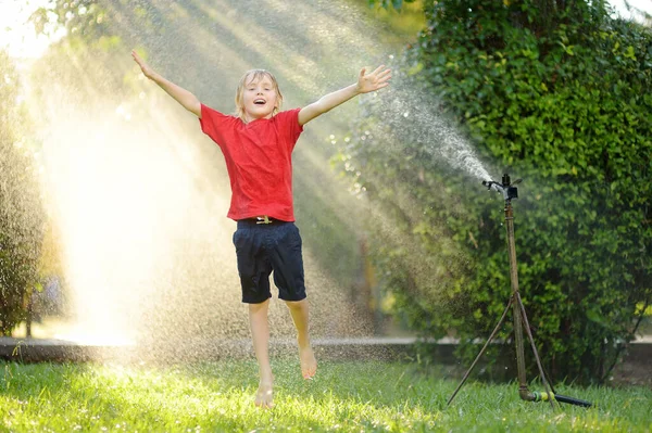 Funny Little Boy Playing Garden Sprinkler Sunny City Park Elementary — Zdjęcie stockowe