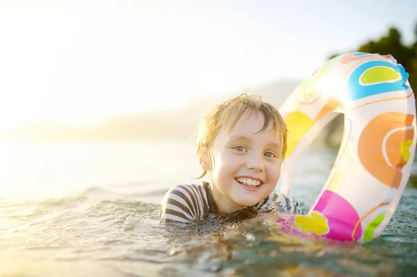 夏天阳光灿烂的日子 小男孩带着五彩缤纷的浮环在海里游泳 可爱的孩子在清澈的水中玩耍 家庭和孩子们在暑假期间度假 海上休息和放松 — 图库照片