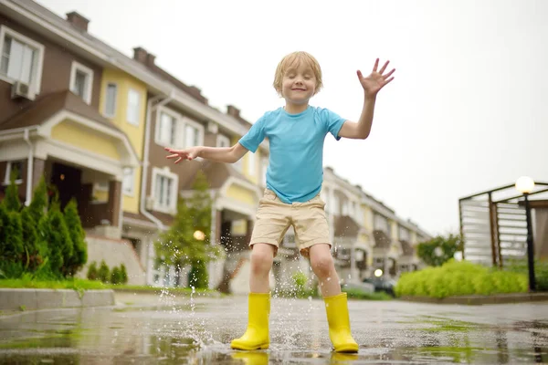 Mały Chłopiec Żółtych Gumowych Butach Skaczący Kałuży Wody Deszczowy Letni — Zdjęcie stockowe