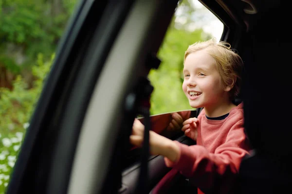 可爱的十多岁男孩在家庭路上从车窗往外看 享受着愉快的假期 喜庆的孩子度假时与父母同行 哪儿都去 — 图库照片