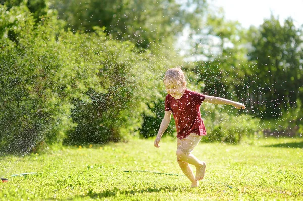 Забавный Маленький Мальчик Играет Садовый Разбрызгиватель Солнечном Заднем Дворе Дошкольник — стоковое фото