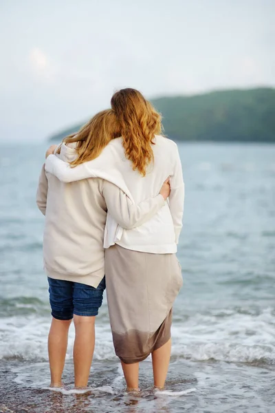 海沿いを歩いているのは 赤毛のお母さんと大人の娘 幸せな愛するお母さんと彼女の大人の子供受け入れと自然の賞賛 — ストック写真