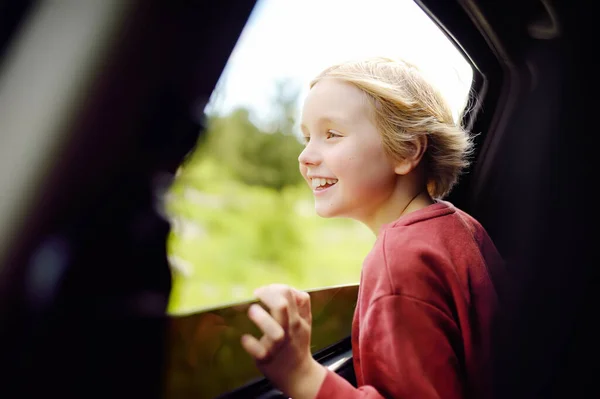 家族の道の旅の間に車の窓から外を見て 幸せな休暇の快適な期待をお楽しみください 休暇中に両親と楽しい子供旅行 どこへでも — ストック写真