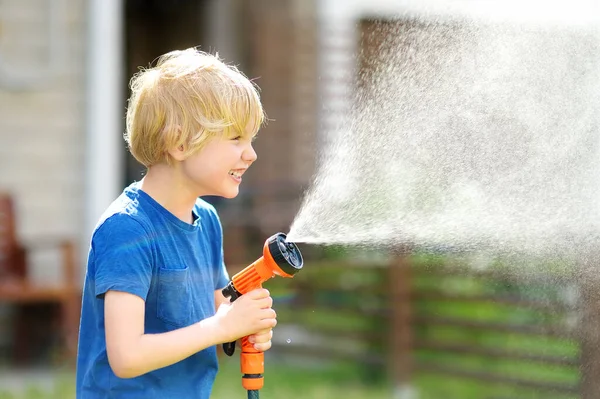 Lustiger Kleiner Junge Wässert Rasen Und Spielt Mit Gartenschlauch Mit — Stockfoto