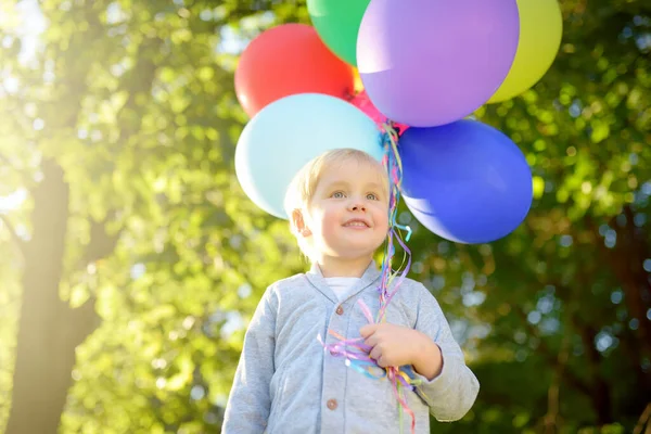かわいい子供が誕生日に友人を祝福するつもりだ お祝いの箱でカラフルな風船や贈り物の束を保持幼児 夏の公園で屋外パーティーを祝う未就学児の赤ちゃん — ストック写真