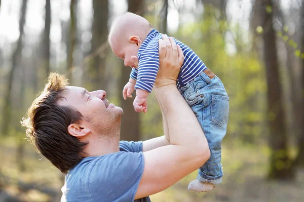 骄傲的父亲在公园散步的时候和他刚出生的儿子一起玩耍 快乐的中年男人把他的小宝宝抛向空中 为人父母 让爸爸照顾他的小儿子 — 图库照片