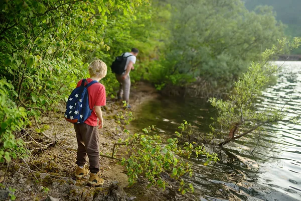 子供の男の子と父親は森の湖に沿ってハイキングや自然を探索しています 森の中を家族旅行 好奇心旺盛な子供たちのための夏休み活動 スカウト オリエンテーリング — ストック写真