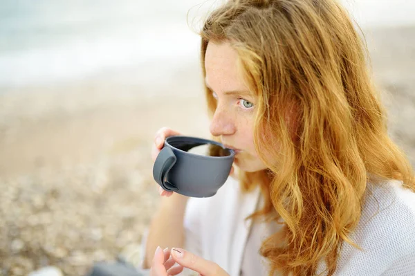 一位年轻漂亮的红头发女子正在海滨野餐 — 图库照片
