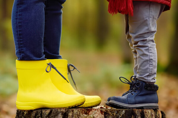 Маленький мальчик со своей молодой матерью во время прогулки по лесу. Активное семейное время на природе. Веселье с маленькими детьми в осенние дни
