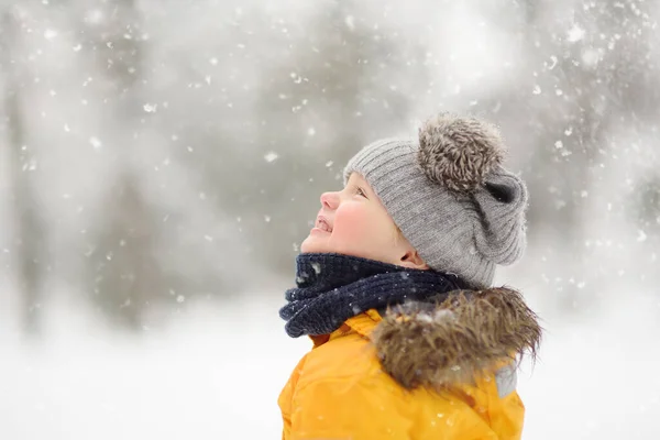 Schattige Kleine Jongen Gele Winterkleren Wandelingen Tijdens Een Sneeuwval Buiten — Stockfoto