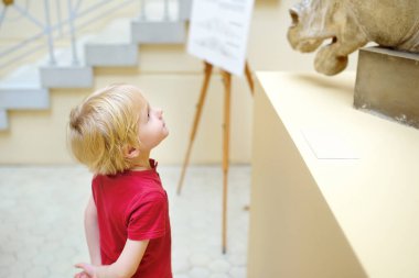 Küçük çocuk at kafasının heykeline bakıyor. Çocukların estetik ve sanat eğitimi.