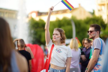 Podgorica, Karadağ - 8 Ekim 2022: On Onur Yürüyüşü sırasında şehir yürüyüşünde gökkuşağı bayrağı taşıyan eylemci. Cinsel azınlıkların eşiti için savaş. Gökkuşağı bayrağı lgbt toplumunun sembolüdür